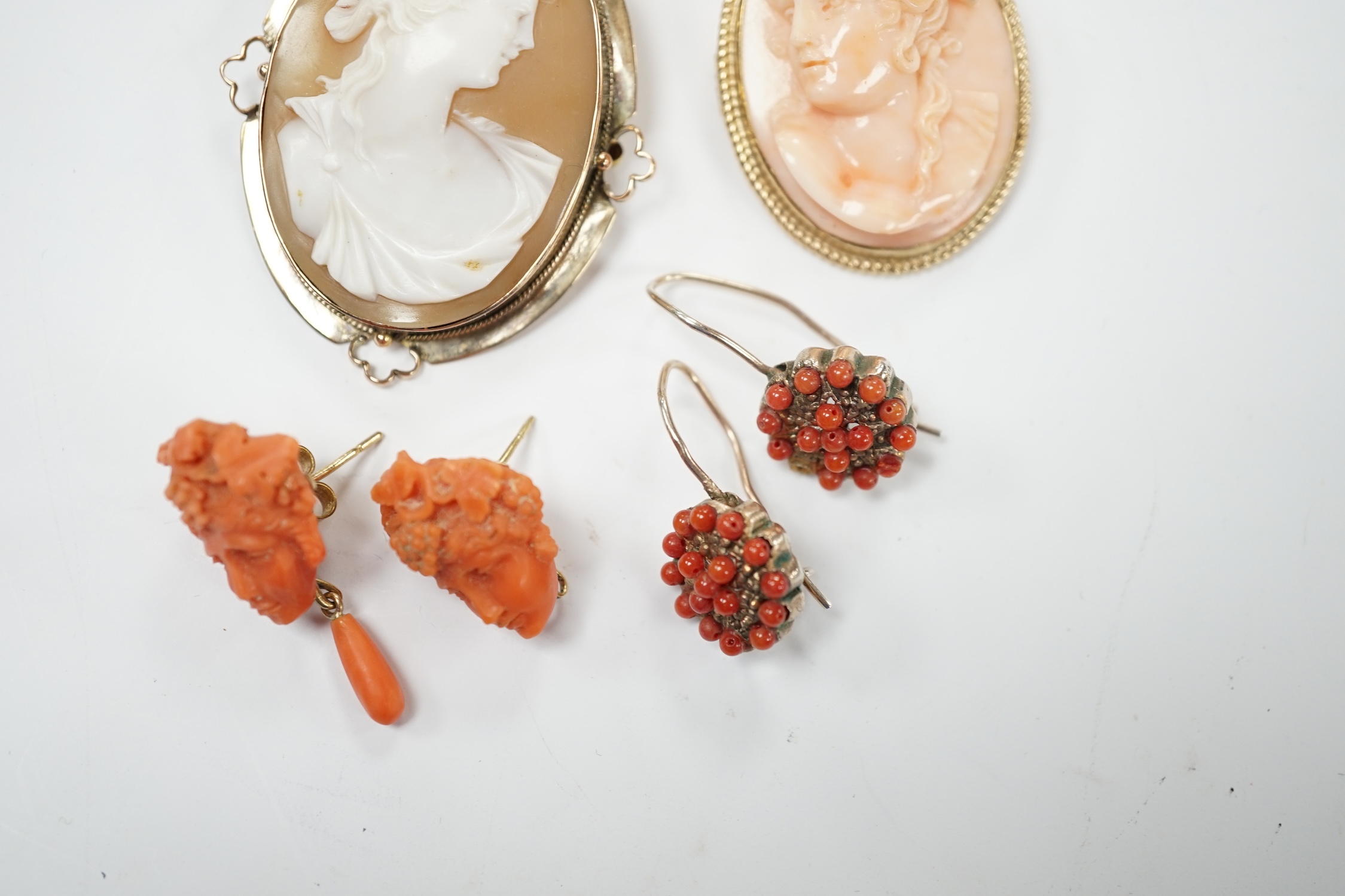 Two pairs of yellow metal and coral set earrings including carved bust (one badly chipped) and two 9ct mounted cameo shell/coral brooches. Poor condition.